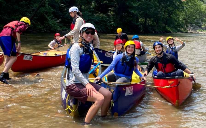a group of students sitting in canoes prepare to navigate whitewater on an outward bound expedition 